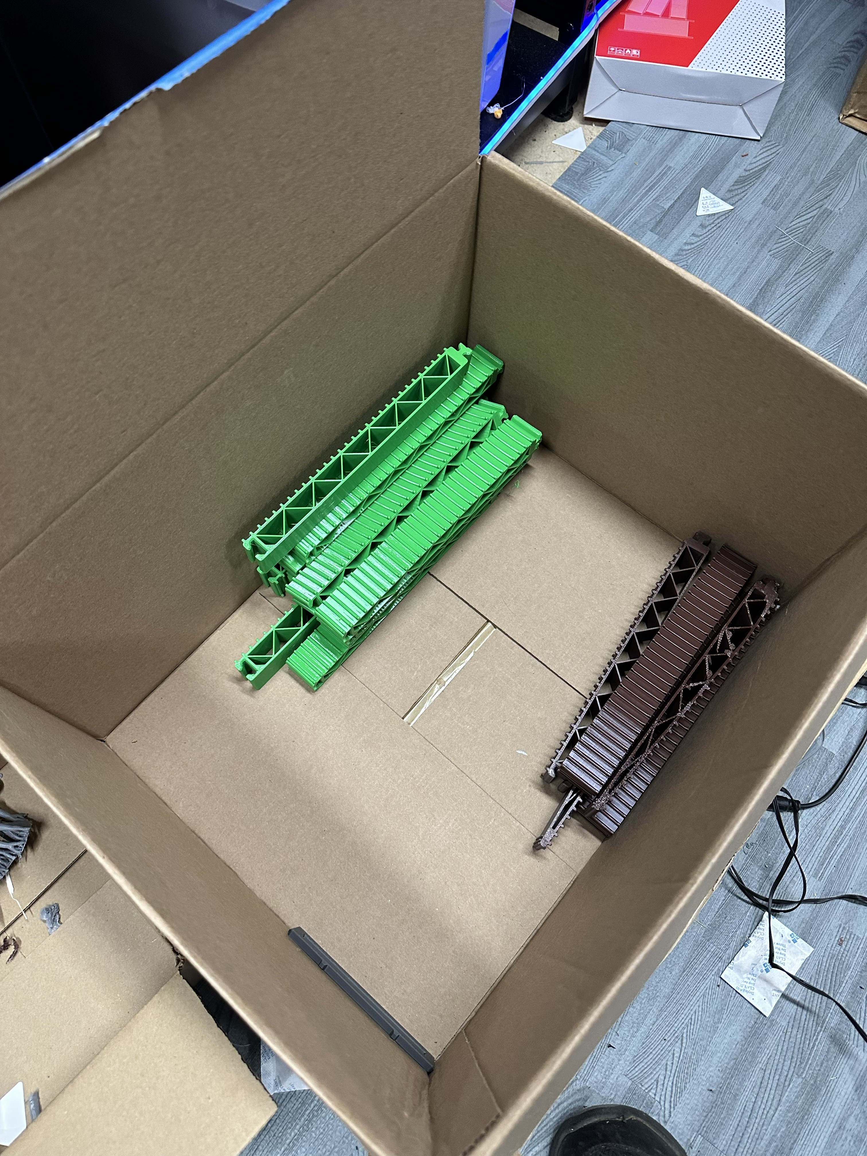 Box of finished green and brown 3D printed Trestle of Doom bridge components